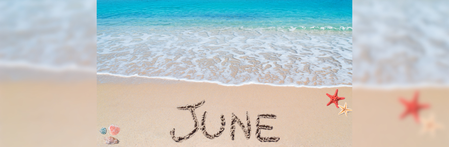 The word 'JUNE' written in the sand on a beach as a wave approaches.