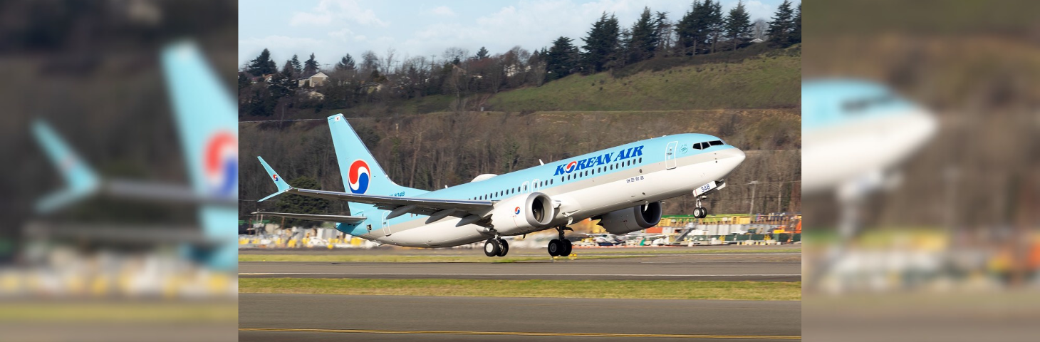 A Korean Air plane taking off on an airport runway.