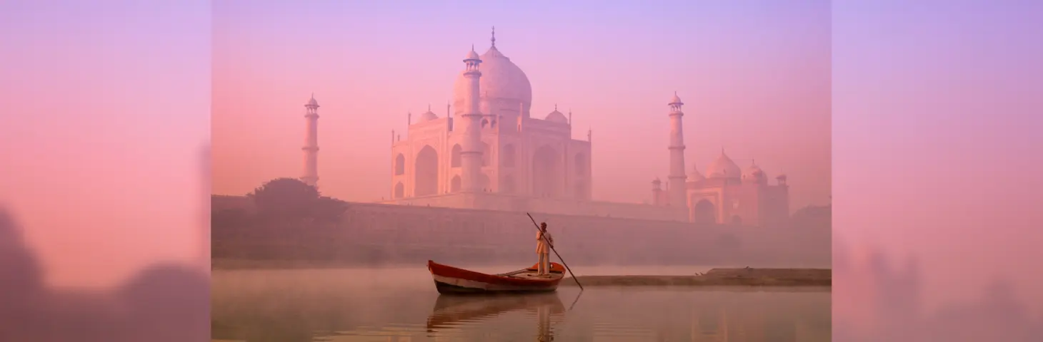 Image of a man in a boat in front of the Taj Mahal 