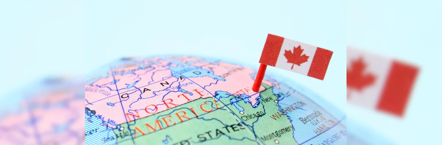 A globe with a Canadian flag pointing towards Canada.