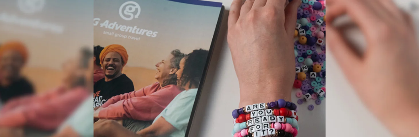 A Taylor Swift fan making beaded bracelets next to a G Adventures brochure.