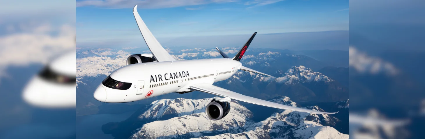 An Air Canada Boeing 787 Dreamliner in flight over the Canadian mountains.