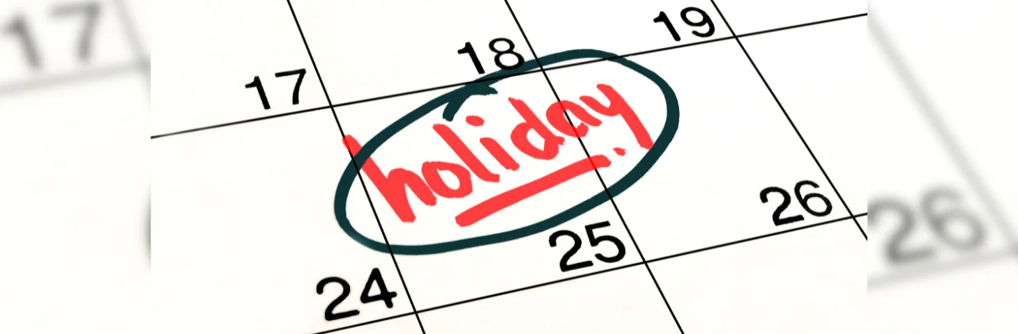 A calendar with 'Holiday' written in red marker over the 25th, circled with black marker.