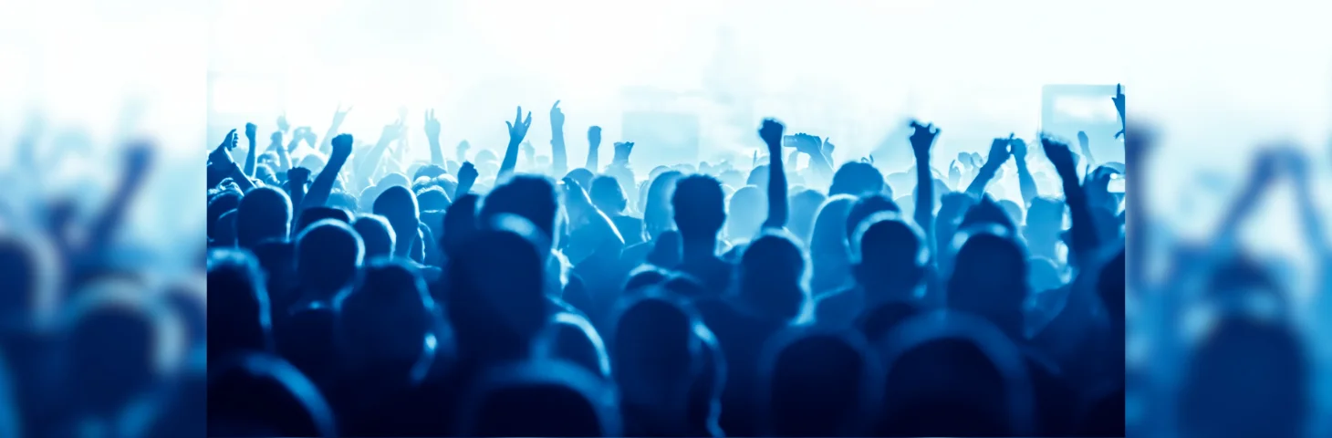 Attendees raising their hands at a concert.