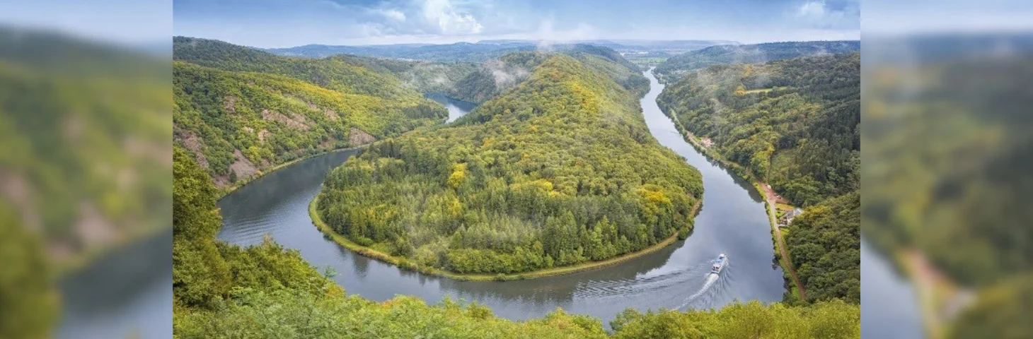 A boat sailing through The Saarschleife in Germany.