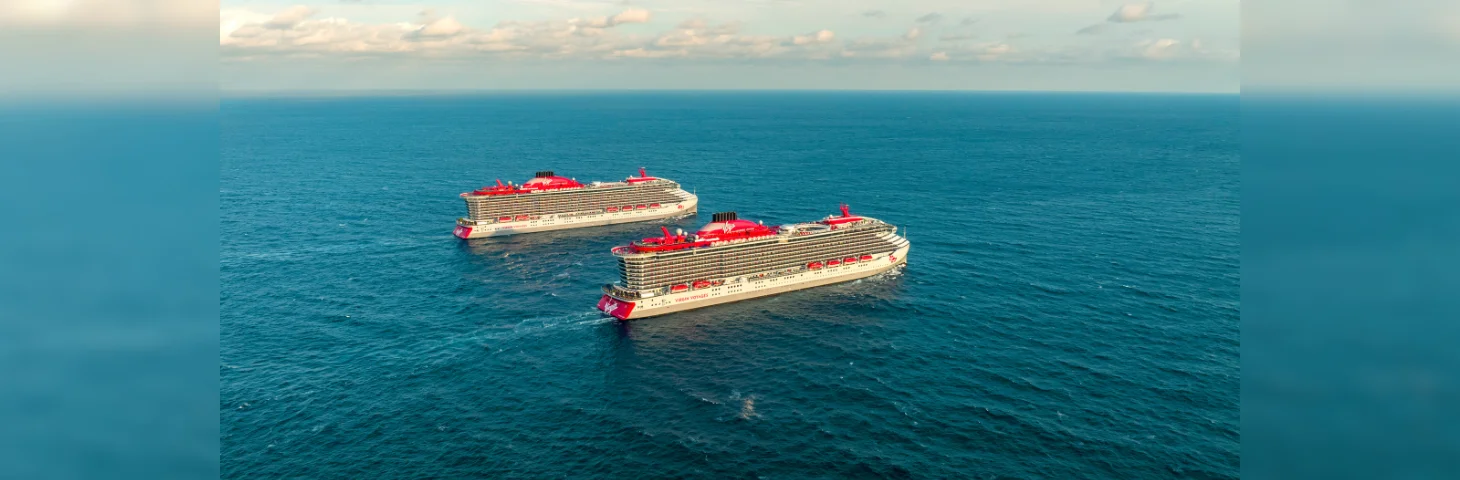 Two Virgin Voyages ships at sea.