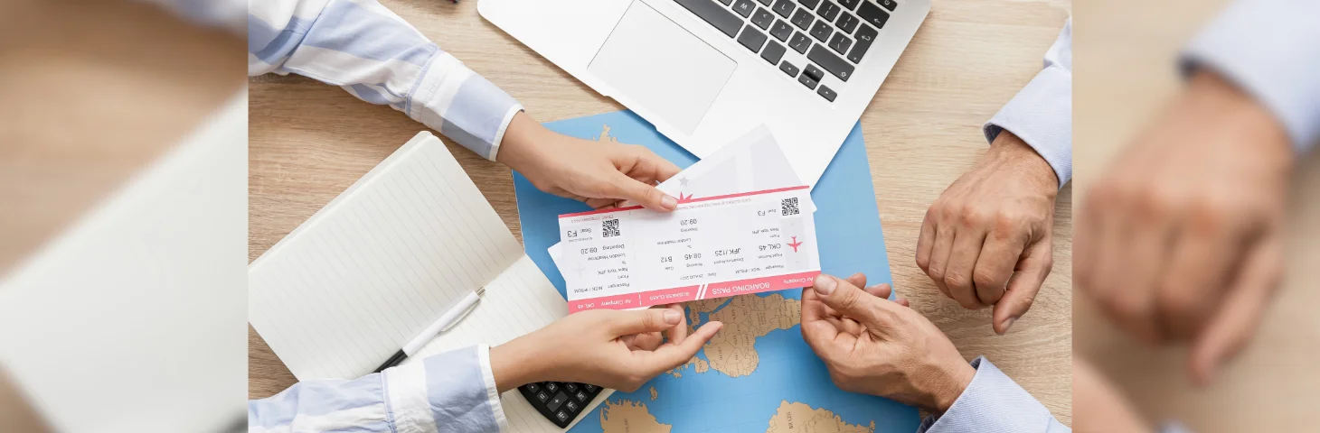 A travel agent handing over boarding passes to a client.