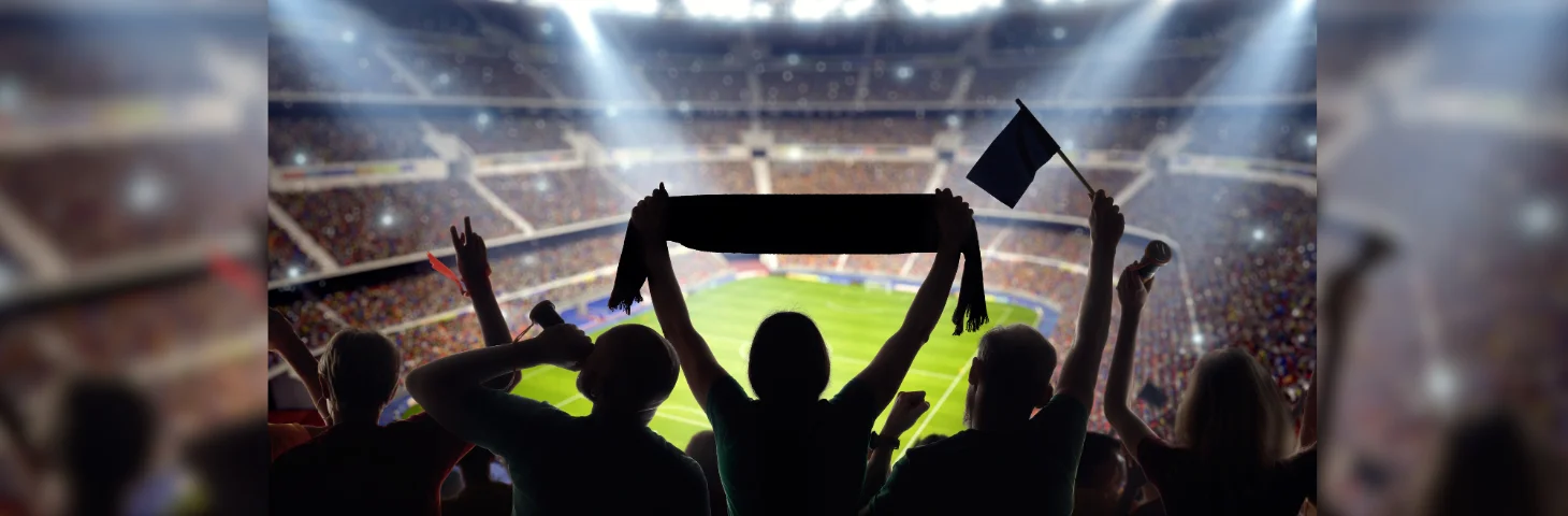 Football fan holding their scarf in the air at a football game.