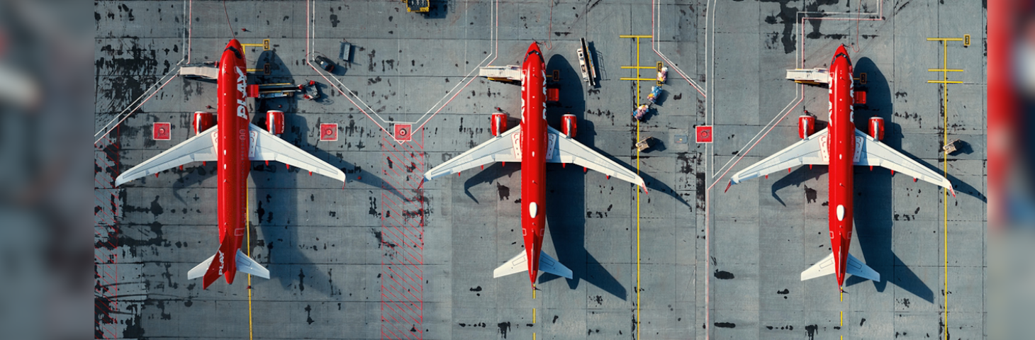 Three PLAY-branded Airbus aircraft on the runway of an airport.