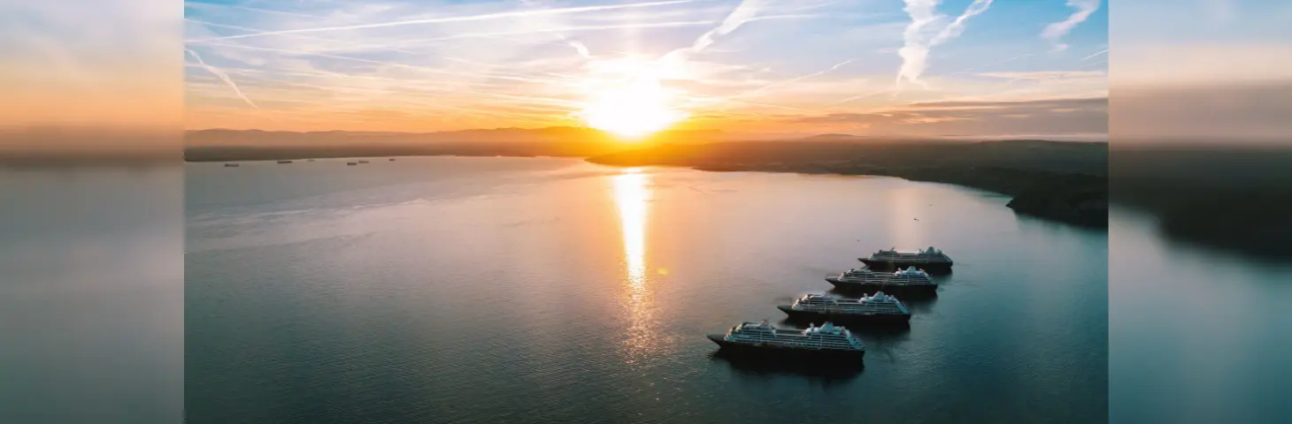 Image of the four Azamara ships in the sea underneath a sunset