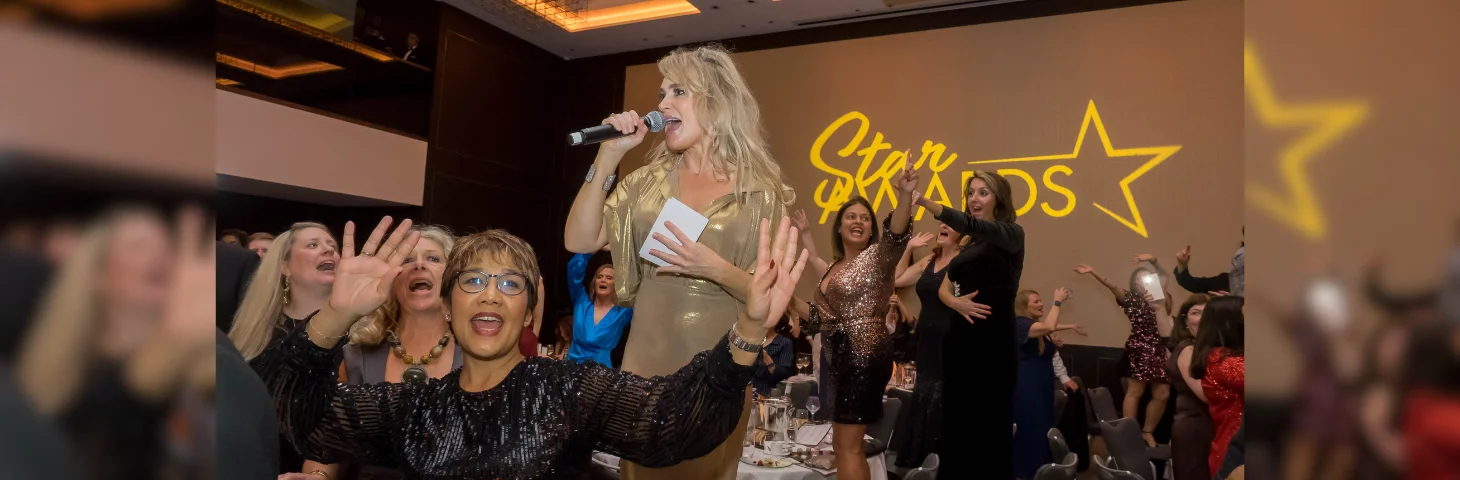 Chrissy Bray, the host of the Travel Bulletin Star Awards 2024, singing karaoke at the Hilton London Bankside.