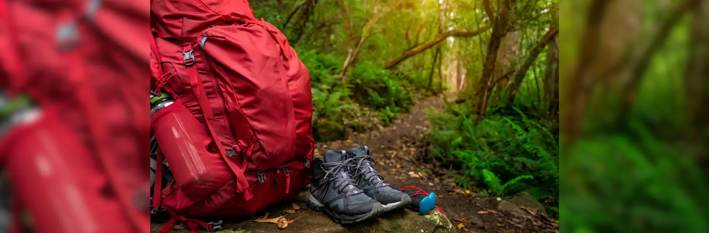 Image of a rucksack and walking shoes in the jungle 