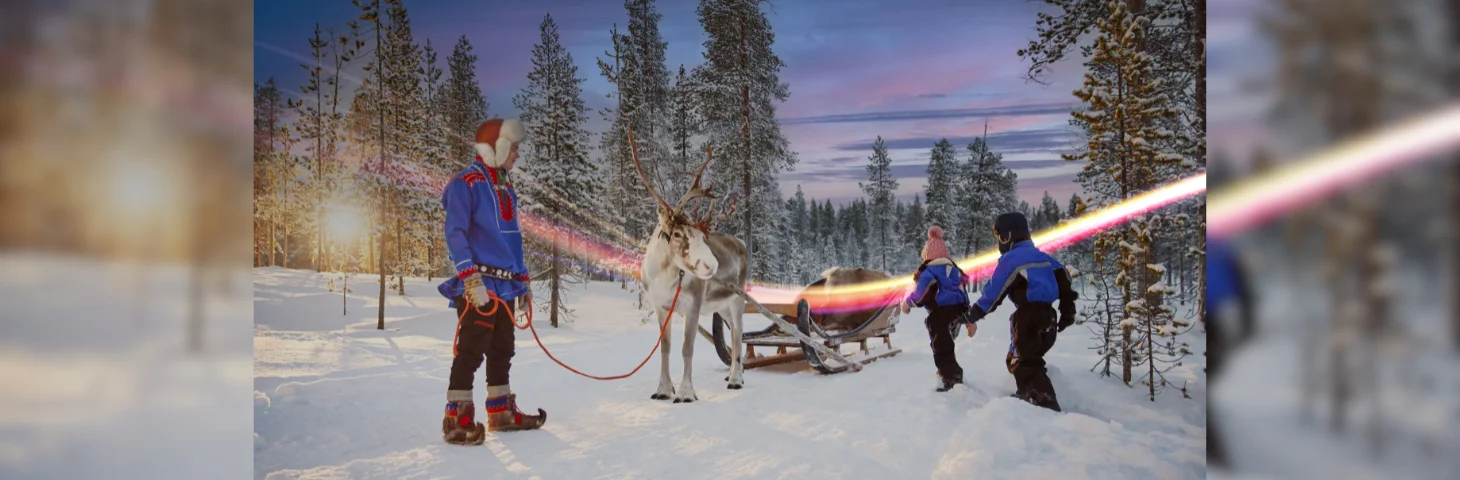 Two children riding a reindeer-pulled sleigh in Lapland.