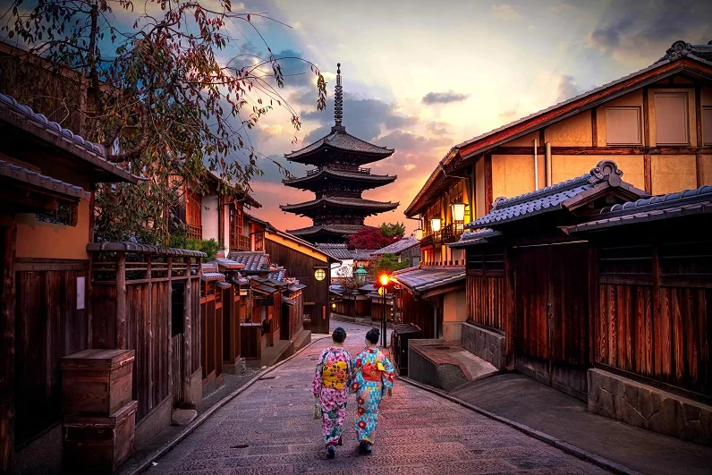 Two geishas wearing traditional japanese kimono among at Yasaka Pagoda and Sannen Zaka Street in Kyoto, Japan. 