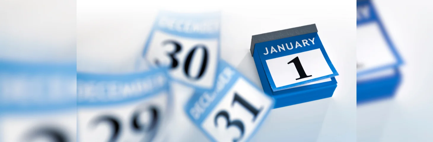 A calendar displaying January 1st, with pages of previous days flying away.