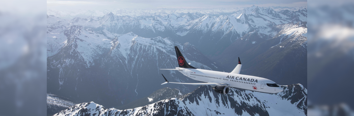 An Air Canada Boeing 787 Dreamliner in flight over the Canadian mountains.