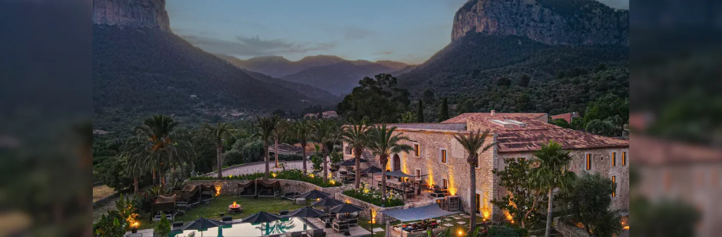 Spirit of Son Fuster, a 14th-century manor house in Mallorca, pictured at dusk, with the Alaro twin mountains in the background.