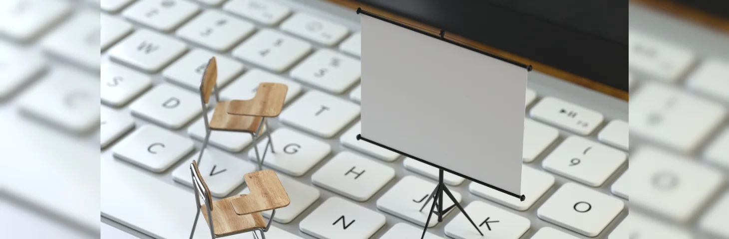 Two miniature school chairs and a projector screen sat atop an Apple keyboard.