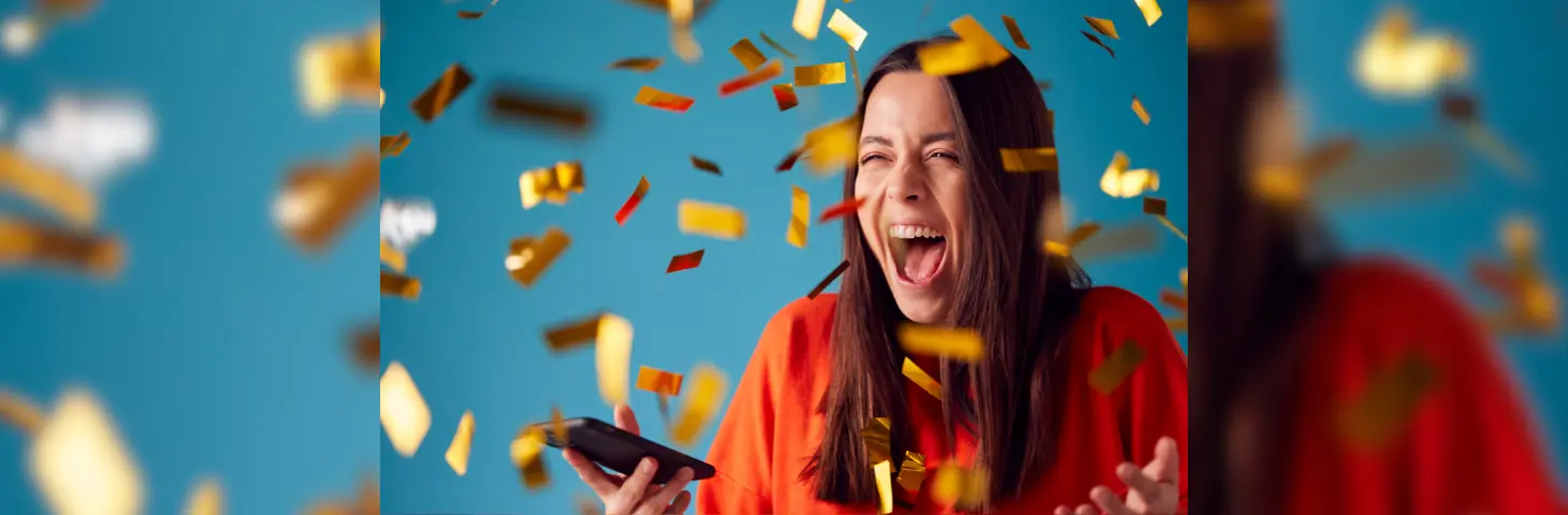 A lady celebrating in confetti after winning something