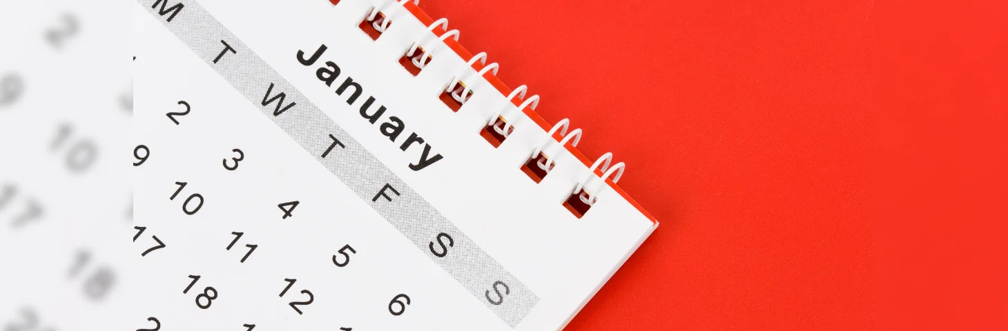 A calendar, against a red background, open on the month of January.