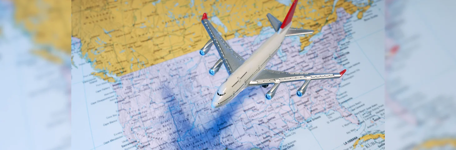 A model plane flying over a map of the USA.