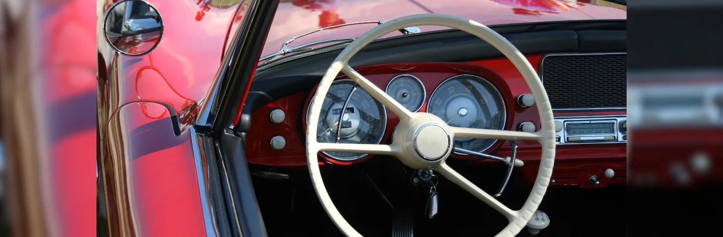 The dashboard of a red Triumph Roadster.