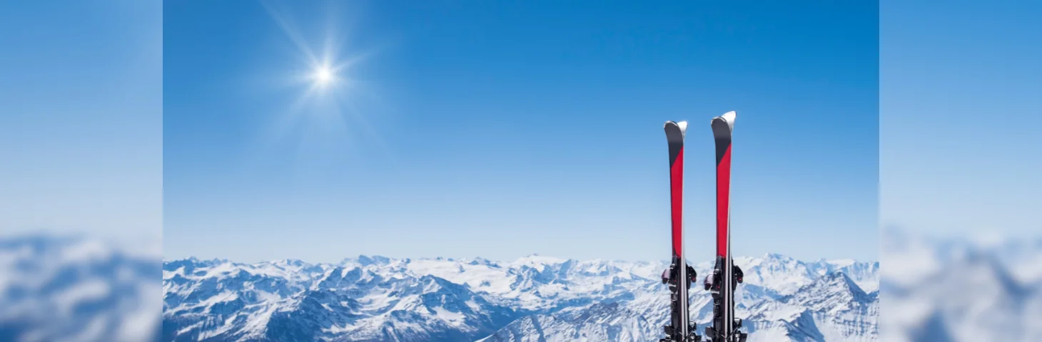 Two red and black skis planted in the snow. 