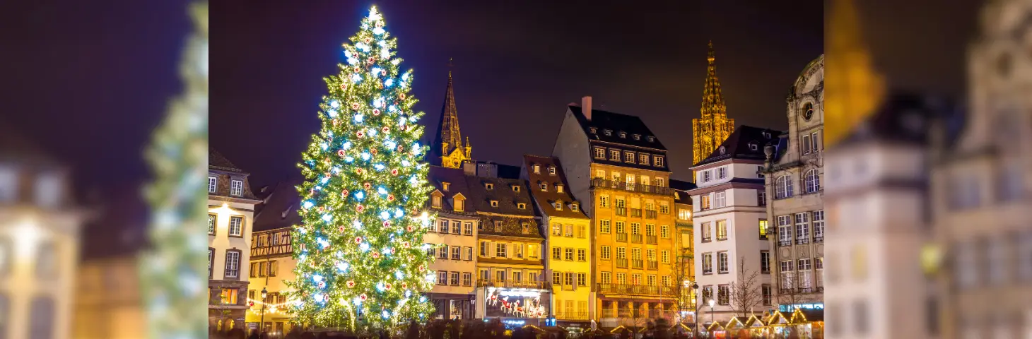 A large lit up Christmas tree in a market