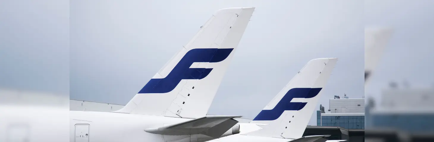 Two aircraft tails with the Finnair logo against a grey skies backdrop