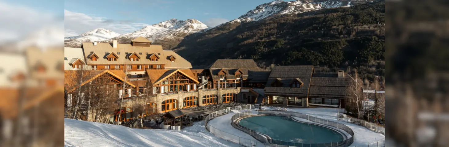 Ariel view of Club Med Sierre Chavilier in front of snow-capped mountains