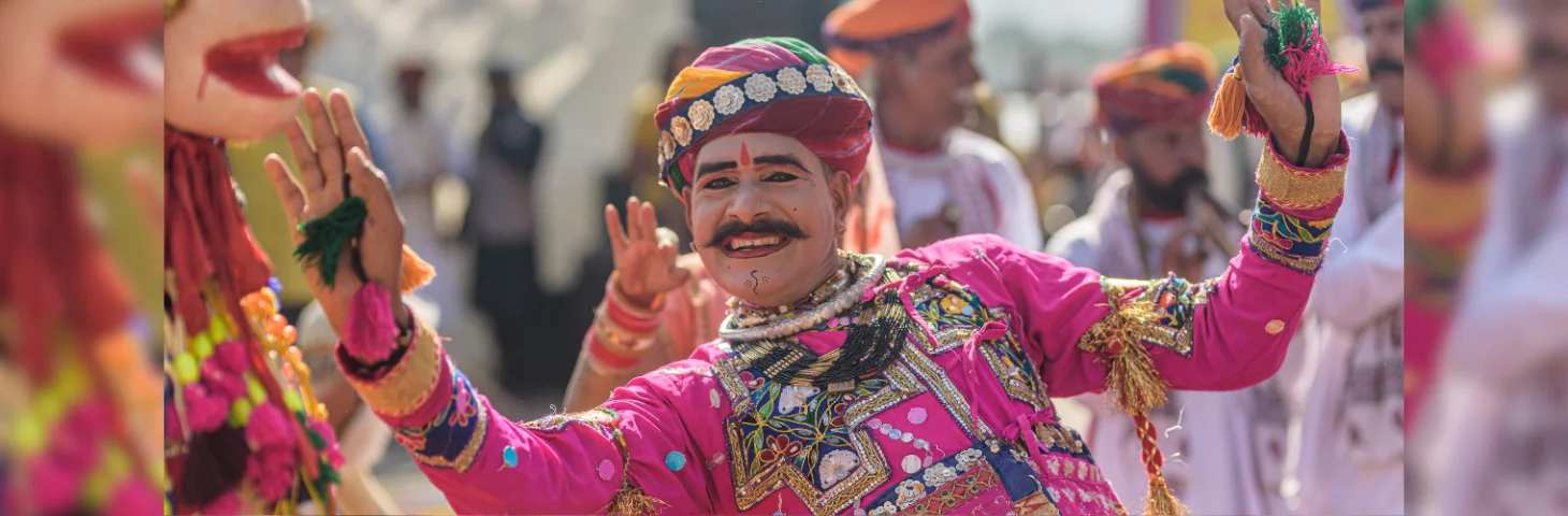 A person in traditional Indian dress celebrating at the Kite Festival in Uttarayan, India.
