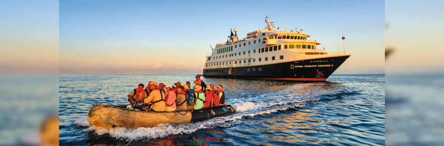National Geographic Endeavour in the background with a small boat of people sailing away from it