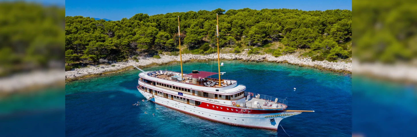 Elegance, a vessel operated by Sail Croatia, docked in an inlet.