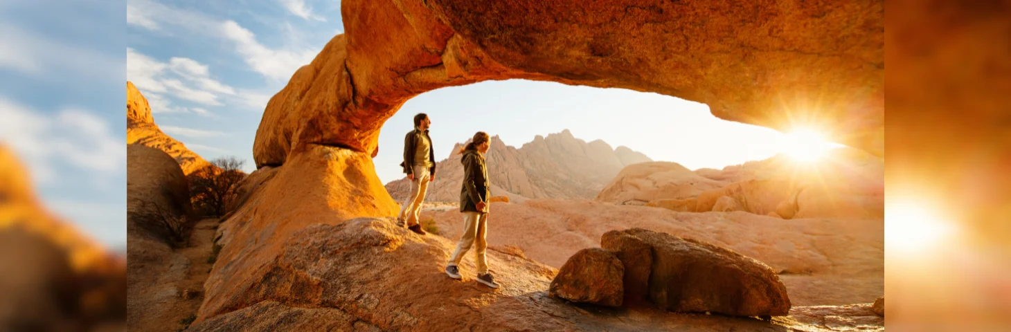 Two people walking among unique rock formations in Spitzkoppe, Namibia.