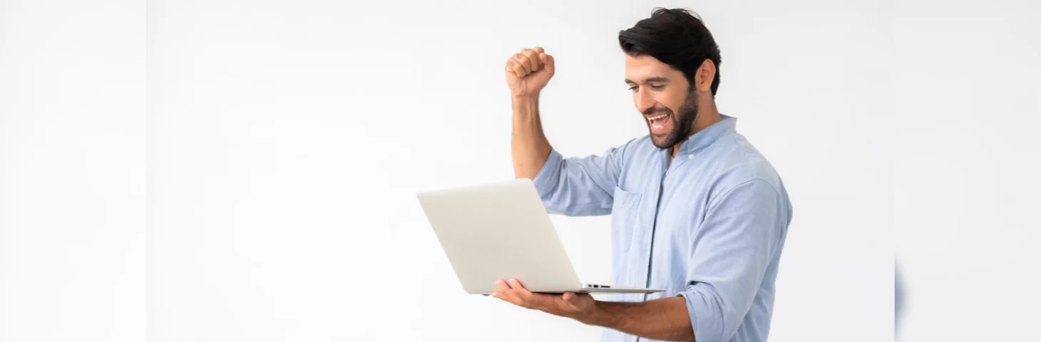 A person celebrating whilst holding their laptop open.