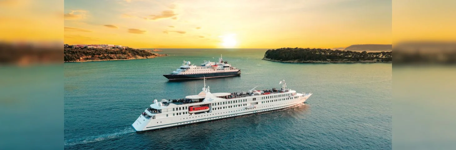 Two CroisiEurope cruise ships, the MS La Belle des Océans and the MS La Belle de l'Adriatique, at sea near sunset.