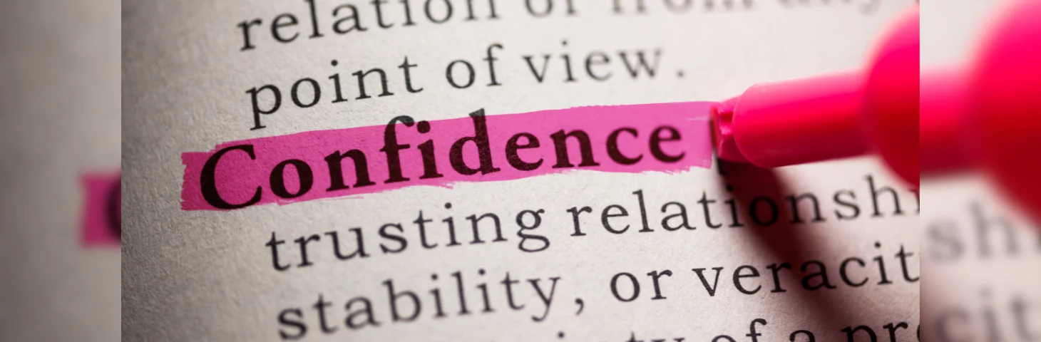 A dictionary entry for the word 'Confidence' being highlighted by a pink highlighter.