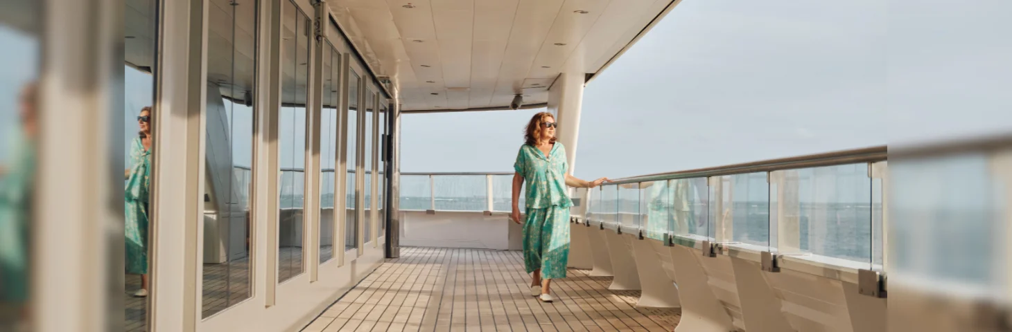 Jane McDonald walking along the deck of a cruise ship.
