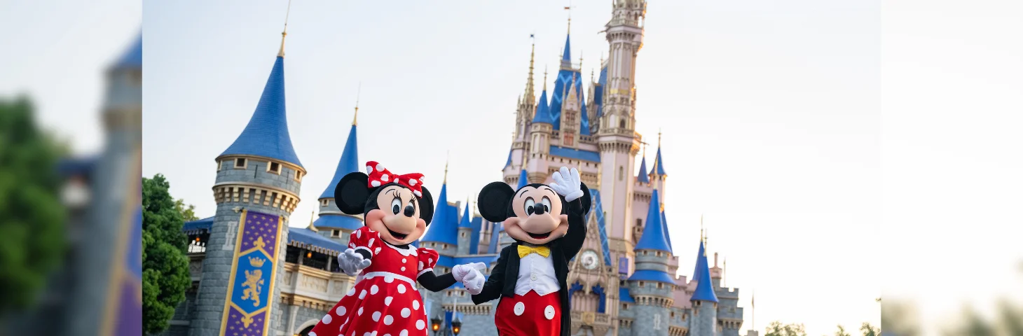 Mickey and Minnie Mouse standing near the Castle at the Magic Kingdom at Walt Disney World Resort in Florida.