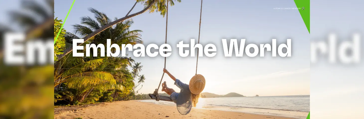 A lady on a swing at the beach with 'Embrace the World' written above