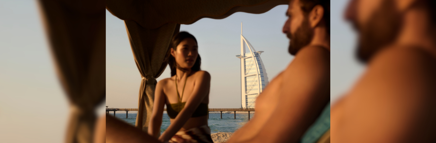 A couple in a coastal cabana with the Jumeirah Burj Al Arab in the background.