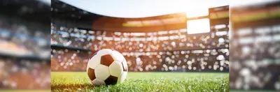 A football on the grass of a stadium.