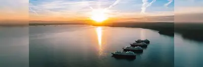Image of the four Azamara ships in the sea underneath a sunset
