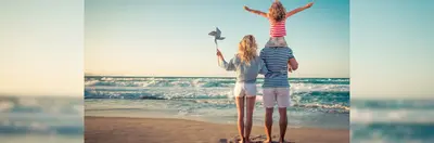 Image of a mother and father with their child on the beach