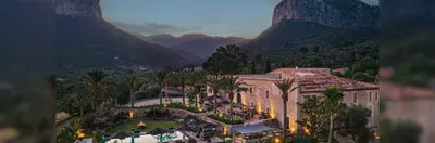 Spirit of Son Fuster, a 14th-century manor house in Mallorca, pictured at dusk, with the Alaro twin mountains in the background.