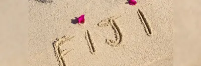 The word 'FIJI' written in the sand. 
