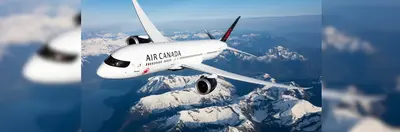 An Air Canada plane flying over snow covered mountains
