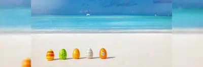 Five Easter eggs on a beach.