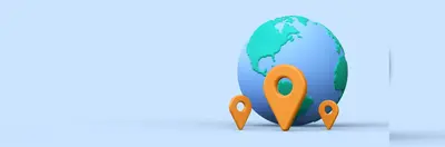 A globe with three orange map pins leant up against it.