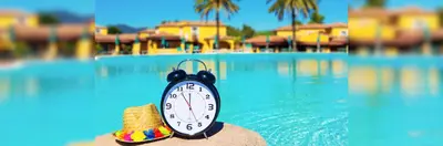 A clock next to a sun hat and swimming pool